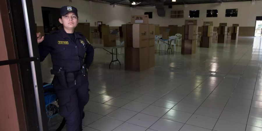 Eine Polizistin steht in einem Wahllokal.
