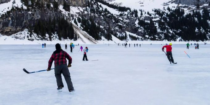 Die grosse Mehrheit der Unfälle bei Eislaufen sind Stürze. Mehrere Personen spielen auf dem gefrorenen Oeschinensee Eishockey.