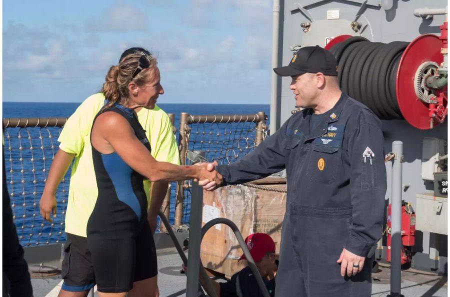 Command Master Chief Gary Wise von der USS Ashland begrüsst eine der Seglerinnen, Jennifer Appel.