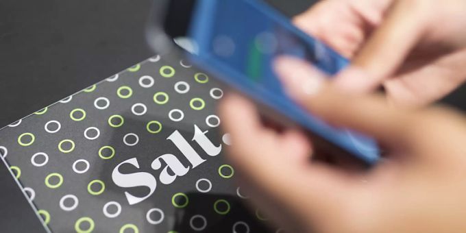 Eine Person bedient in einem Geschäft von Salt ein Smartphone. Salt Smartphone