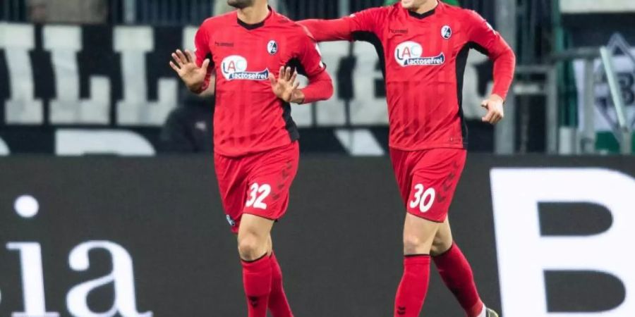 Torschütze Vincenzo Grifo (l) feiert mit seinem Teamkollegen Christian Günter den Treffer gegen Gladbach. Foto: Marcel Kusch