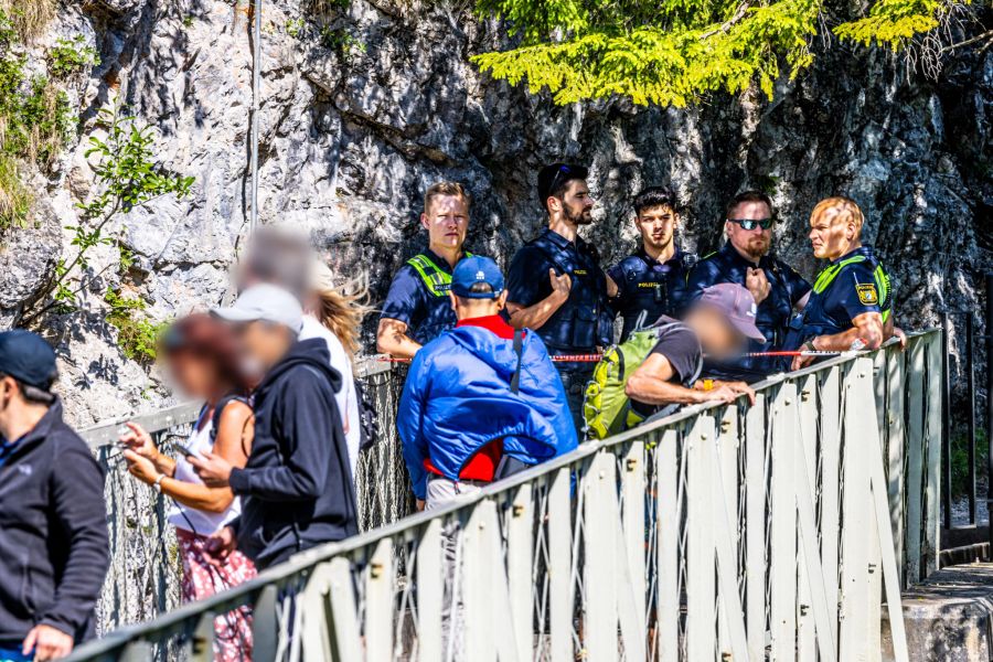 Polizisten und Passanten stehen an der Marienbrücke an einer Absperrung.