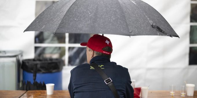 Ein Besucher sitzt am Nationalfeiertag im Regen. rütli