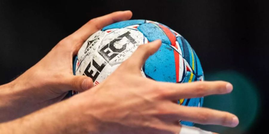 Ein Ball in der Hand eines Spielers. Foto: Robert Michael/dpa