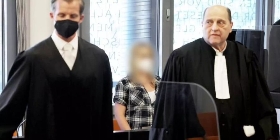 Die angeklagte Mutter zwischen ihren Anwälten Felix Menke (l) und Thomas Seifert (r) im Gerichtssaal. Foto: Oliver Berg/dpa