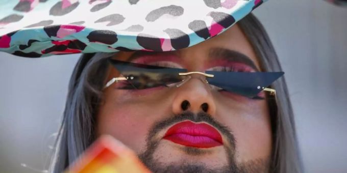 Ein Teilnehmer fächert sich bei der jährlichen Pride Parade Luft mit einem regenbogenfarbenen Fächer zu. Foto: Ariel Schalit/AP/dpa Ein Teilnehmer fächert sich bei der jährlichen Pride Parade Luft mit einem regenbogenfarbenen Fächer zu. Foto: Ariel Schalit/AP/dpa