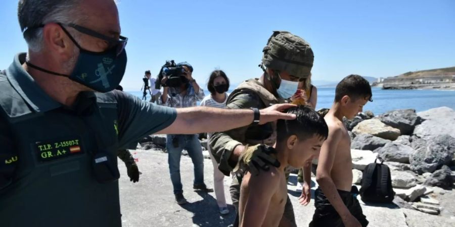 Spanische Sicherheitskräfte helfen Minderjährigen nach ihrer Ankunft in Ceuta