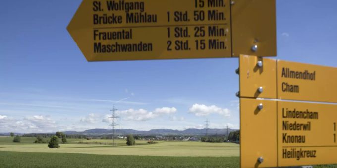 Wanderweg-Schilder vor Hünenberg im Hintergrund. (Symbolbild) Hünenberg