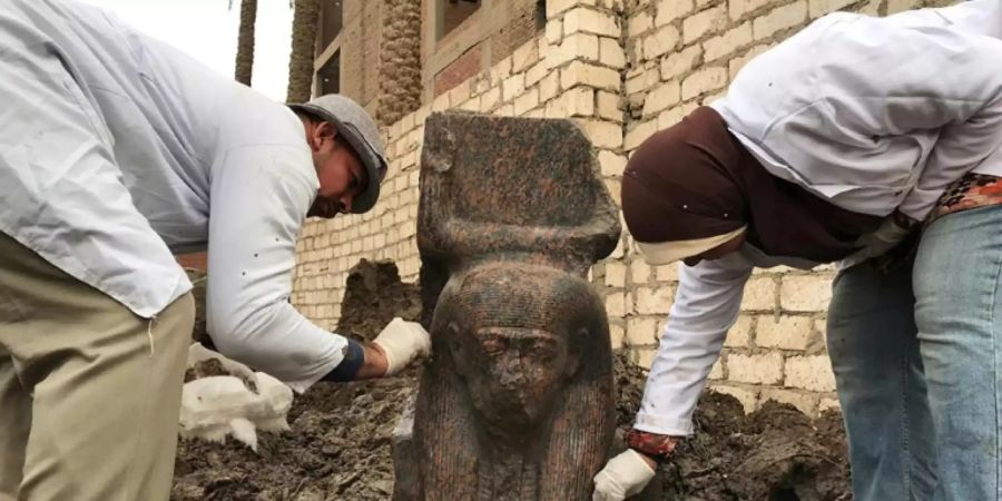 Ägyptische Archäologen mit der Statue von Ramses II.