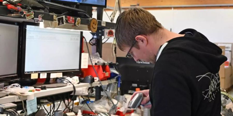 Ein Mitarbeiter des Retourenvermarkter Avides überprüft ein elektronisches Gerät. Foto: Carmen Jaspersen/dpa