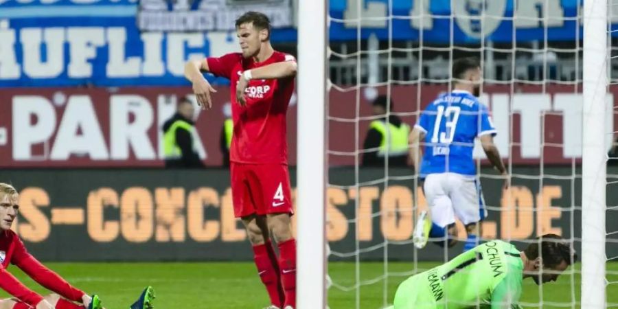 Bochum-Keeper Manuel Riemann ist geschlagen - Kiels Janni Serra (hinten) dreht nach seinem Tor zum 2:1 jubelnd ab. Foto: Frank Molter/dpa