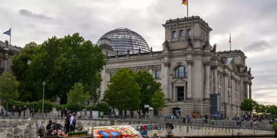Demonstranten fahren mit einem Boot am Berliner Reichstagsgebäude vorbei. Das Klimapaket der Bundesregierung wird von Opposition, Umweltschützern und Wirtschaftsverbänden weiter scharf kritisiert. Foto: Christophe Gateau