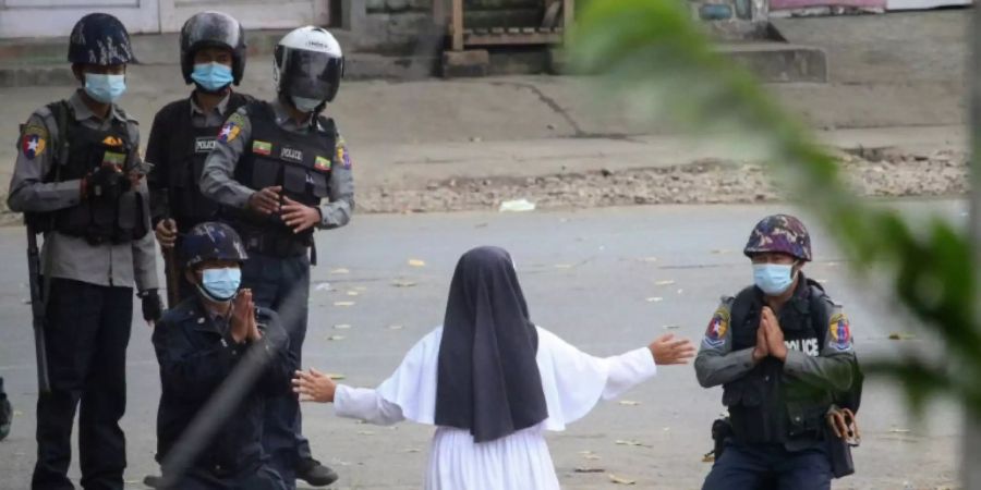 Eine Nonne stellt sich den Sicherheitskräften in Myitkyina in den Weg