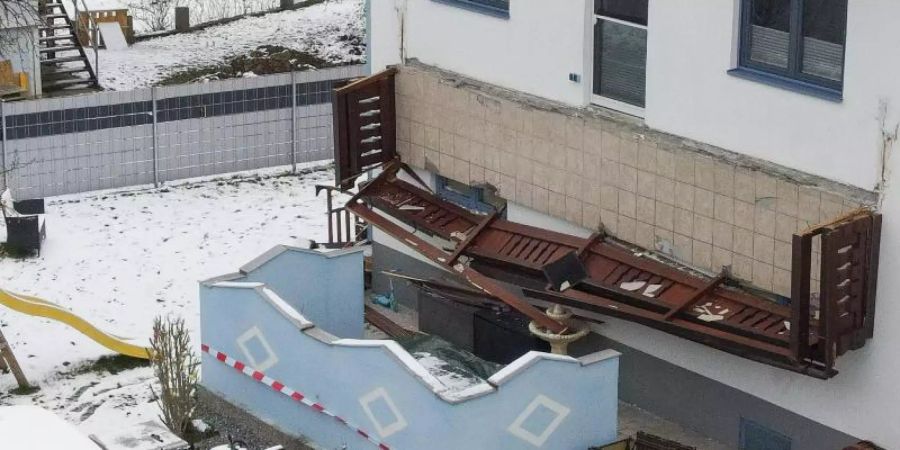 Ein abgestürzter Balkon hängt senkrecht an einer Hauswand. Drei Frauen und ein Kleinkind sind dreieinhalb Meter abgestürzt. Foto: Fotokerschi.At/Werner Kerschbaum/APA/dpa