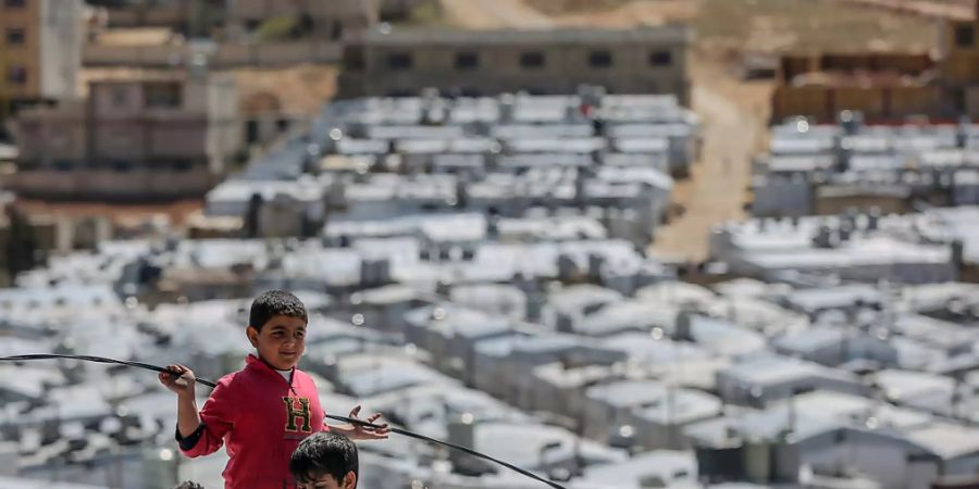ARCHIV - Syrische Jungen spielen auf dem Dach einer Unterkunft im Flüchtlingslager Barra nordöstlich der libanesischen Hauptstadt Beirut. Foto: Marwan Naamani/dpa