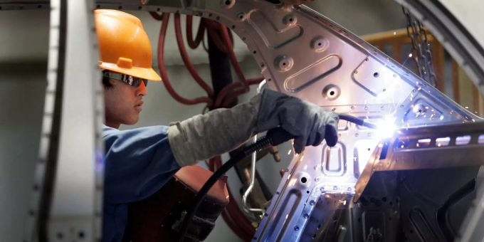 Ein Arbeiter schweisst den Innenraum eines Autos in einer Autofabrik in China. Menschenrechtsgruppen glauben das in China hunderttausende Uiguren zur Zwangsarbeit gezwungen werden. (Symbolbild) Uiguren Autofabrik