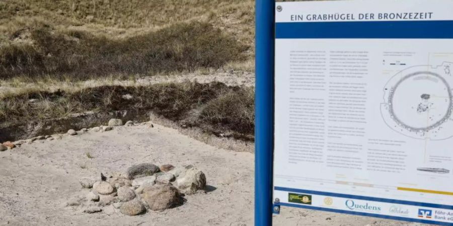 Ein Grabhügel aus der Bronzezeit ist als Denkmal in den Dünen am Strand zu sehen. Foto: Frank Molter/dpa