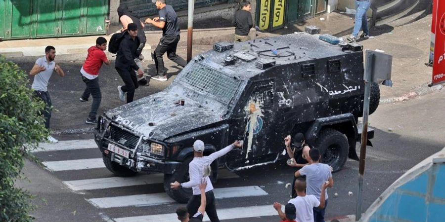 Protestierende bewerfen ein Auto in Nablus