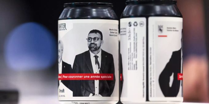 Bierdosen mit einem Bild des Praesidiums (Stefan Costa, Herve Gullotti, Martin Schlup), welche als Dankeschoen an die Raete verteilt wurden, stehen auf einem Tisch. stefan costa