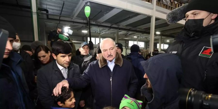 Der belarussische Machthaber Alexander Lukaschenko spricht mit Migranten in einem Logistikzentrum an der polnisch-belarussischen Grenze. Foto: BelTA/XinHua/dpa