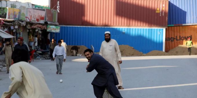 Menschen spielen auf einer wegen den Protesten gesperrten Strasse Cricket. protestmarsch