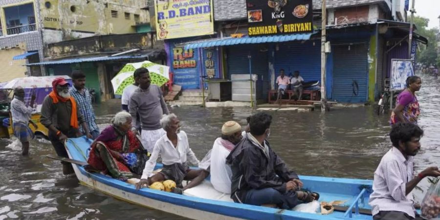 In Indien: Im Boot durch die überfluteten Strassen. Foto: R. Parthibhan/AP/dpa