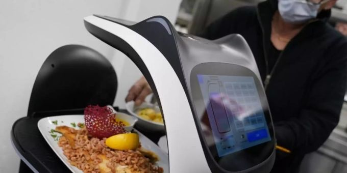 Der Roboter «Bella» wird in der Küche des Restaurants in Grömitz mit Gerichten für die Gäste beladen. Foto: Marcus Brandt/dpa Roboter Bella