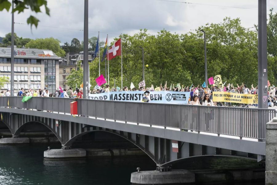 Aktivisten von Extinction Rebellion stehen am 20. Juni 2020 auf der Quaibrücke in Zürich und halten Plakate in die Höhe.