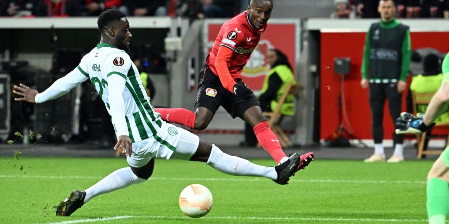 Leverkusens Moussa Diaby (r.) schiebt den Ball an Budapests Myenty Abena vorbei aufs Tor.