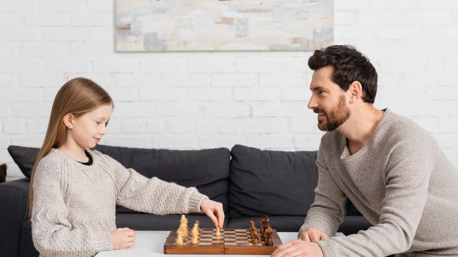 Tochter und Vater spielen Schach