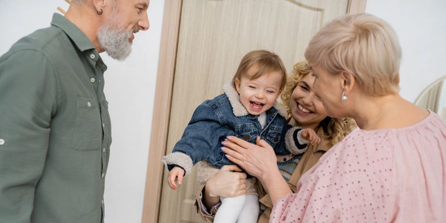 Fröhliches Kind mit Mutter und Grosseltern