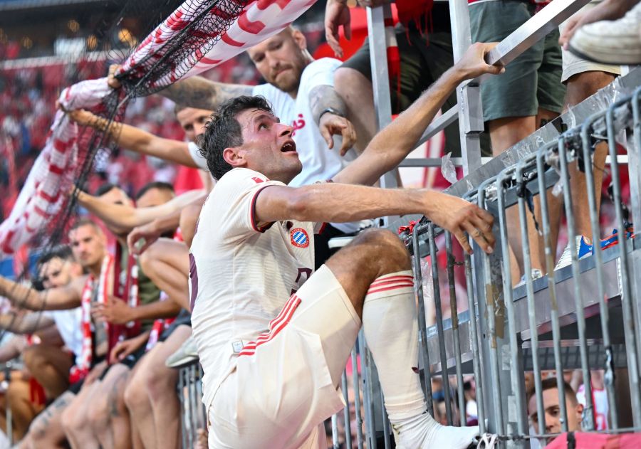 Thomas Müller steigt nach dem Bayern-Sieg auf den Zaun zu den Fans. Sven Hoppe/dpa