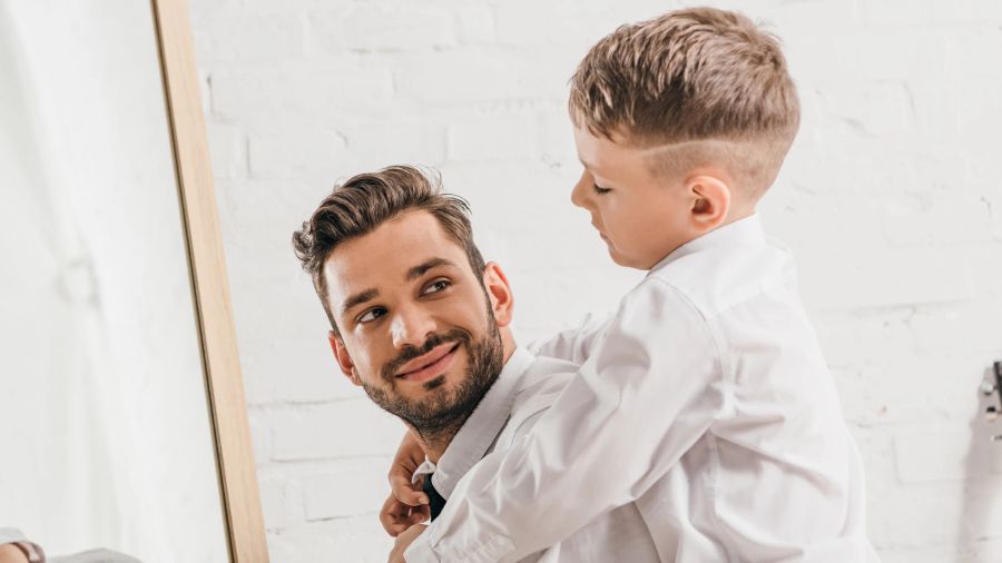 vater und sohn, lächeln sich einander zu