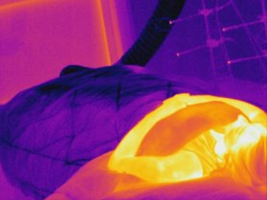 Dieses Bild zeigt eine Person, die in einem Bett mit gekühlter Bettdecke liegt.