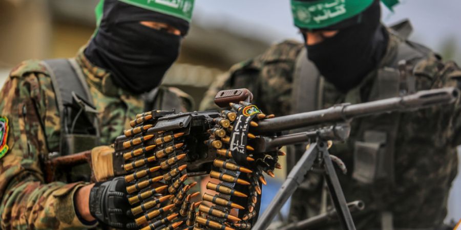 ARCHIV - Vermummte Kämpfer der Kassam-Brigaden, des militärischen Flügels der islamistischen Terrororganisation Hamas, hantieren mit Waffen. Foto: Abed Rahim Khatib/dpa/Archivbild