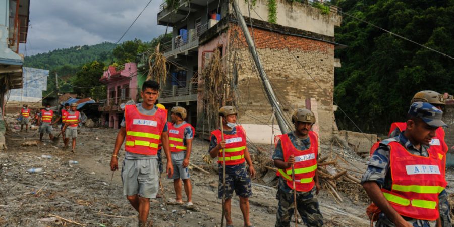 Arbeiter räumen nach einer Sturzflut im Gebiet Devighat im Distrikt Nuwakot Trümmer weg. Foto: Rajesh Kumar Singh/AP/dpa