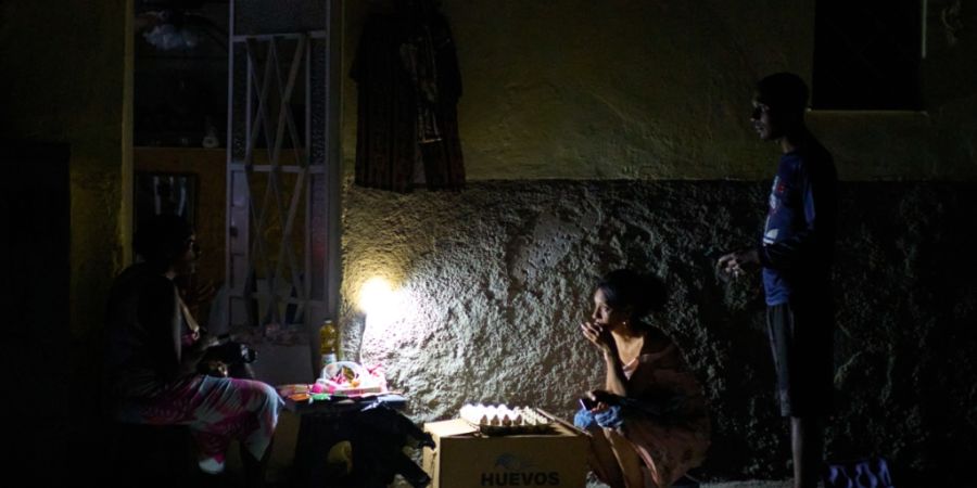 ARCHIV - Straßenverkäufer unterhalten sich während eines Stromausfalls in Havanna. Foto: Ramon Espinosa/AP/dpa