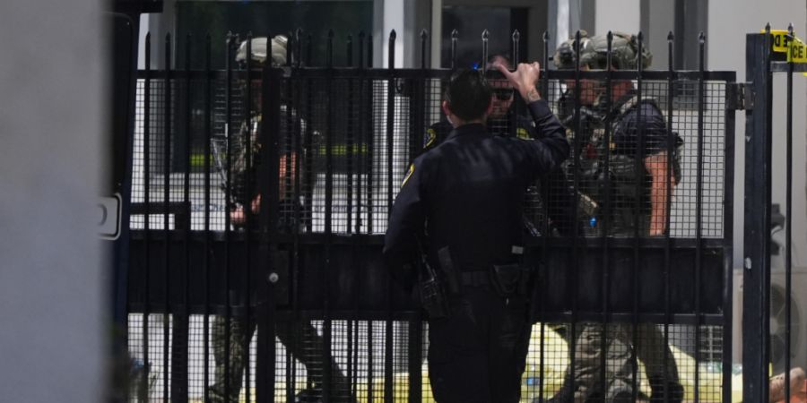 Einsatzkräfte gehen an einem mit Plane abgedeckten Opfer vorbei am Tatort nach Schüssen vor dem Islamic Center of San Diego. Foto: Gregory Bull/AP/dpa