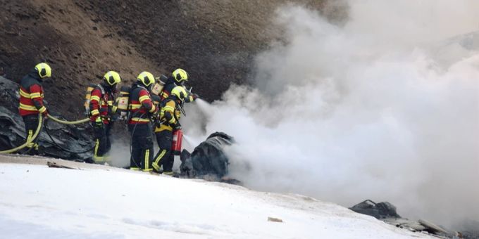 Feuerwehrleute löschen den Brand in der am Montag im Engadin abgestürzten Maschine. Flugzeugabsturz Engadin