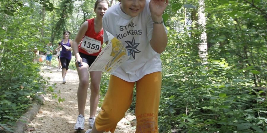 Hier halten sich die Zecken besonders gerne auf: Kinder an einem Orientierungslauf für Schüler und Schülerinnen im Wald. (Archivbild)