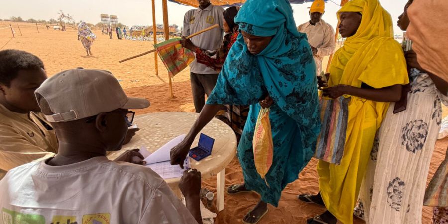 ARCHIV - Ehe sudanesische Flüchtlingsfrauen ihre Lebensmittelrationen im Flüchtlingslager Aboutengé im Osten des Tschad erhalten, müssen sie einen Berechtigungsschein vorzeigen und ...