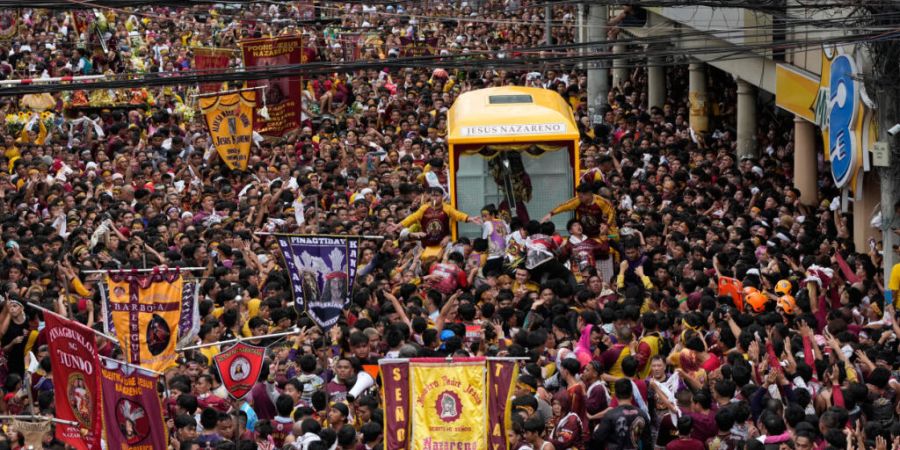 Katholische Gläubige versammeln sich während der jährlichen Prozession um die Kutsche mit dem Bildnis des Schwarzen Nazareners. Foto: Aaron Favila/AP/dpa
