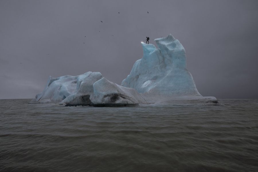 Eine Person brennt die Spitze einer Eisscholle ab in «The Blue Fossil Entropic Stories III» (2013) von Julian Charrière.