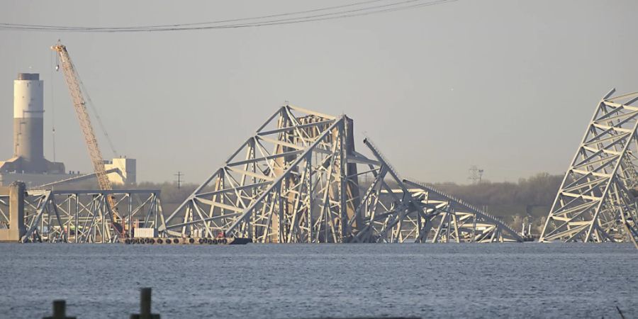 Ein Kran ist in der Nähe der Trümmer der Francis Scott Key Bridge zu sehen. Foto: Steve Ruark/FR96543 AP/AP/dpa