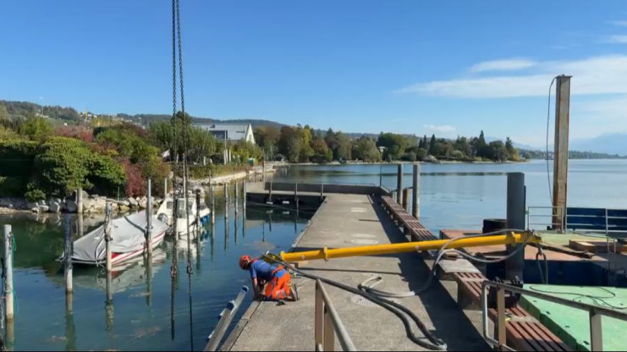 Der Schwimmsteg wird mit einem Kran leicht angehoben und in Richtung Rapperswil verschoben.