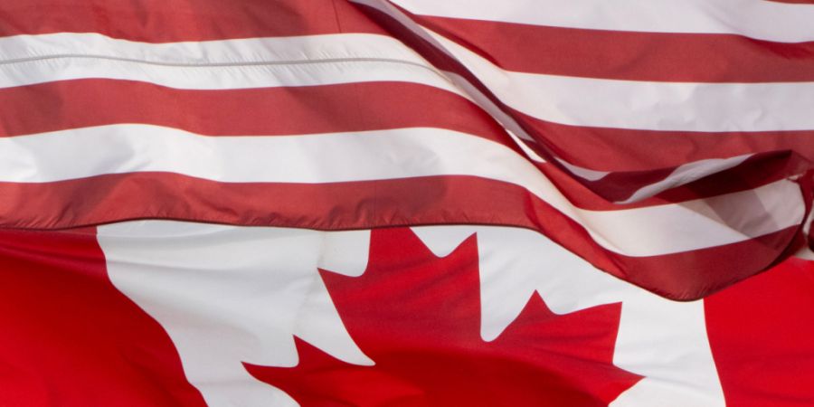 ARCHIV - Die Flaggen Kanadas und der Vereinigten Staaten wehen über einem Stadion in Ottawa. Foto: Adrian Wyld/The Canadian Press/dpa/Archivbild - ACHTUNG: Nur zur redaktionellen Verwe...
