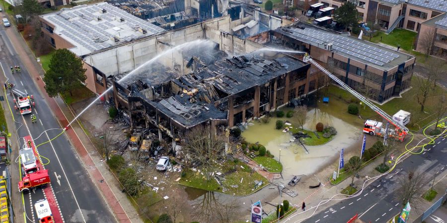 Die Feuerwehr löscht letzte Glutnester in einer Lagerhalle nach einem Grossbrand in Düsseldorf.