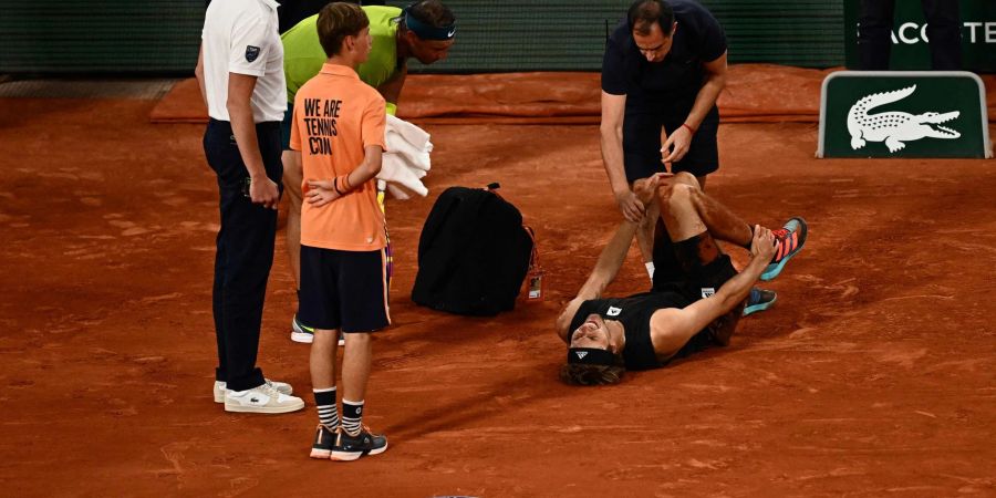 Alexander Zverev (2.v.r) wird während des Spiels gegen Rafael Nadal (2.v.l) medizinisch behandelt.