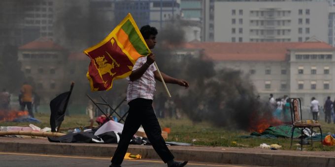 Ein Unterstützer der srilankischen Regierung trägt eine Nationalfahne. Ein Unterstützer der srilankischen Regierung trägt eine Nationalfahne.