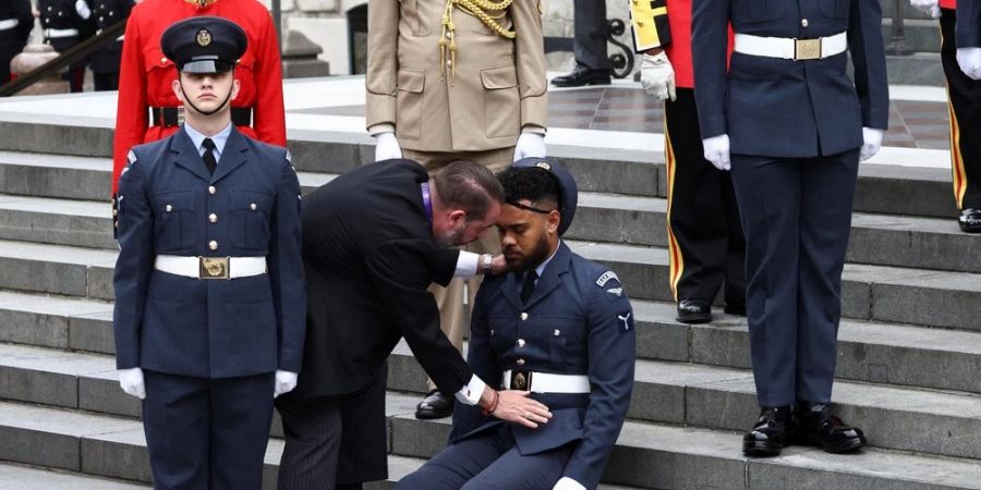 Einer der drei umgekippten Soldaten sitzt auf den Stufen der St.-Pauls-Kathedrale in London.